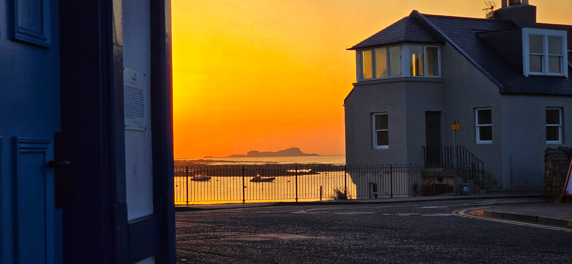 A coastal home in North Berwick at twilight, warm lights glowing